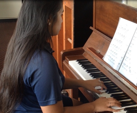 Student playing a piano